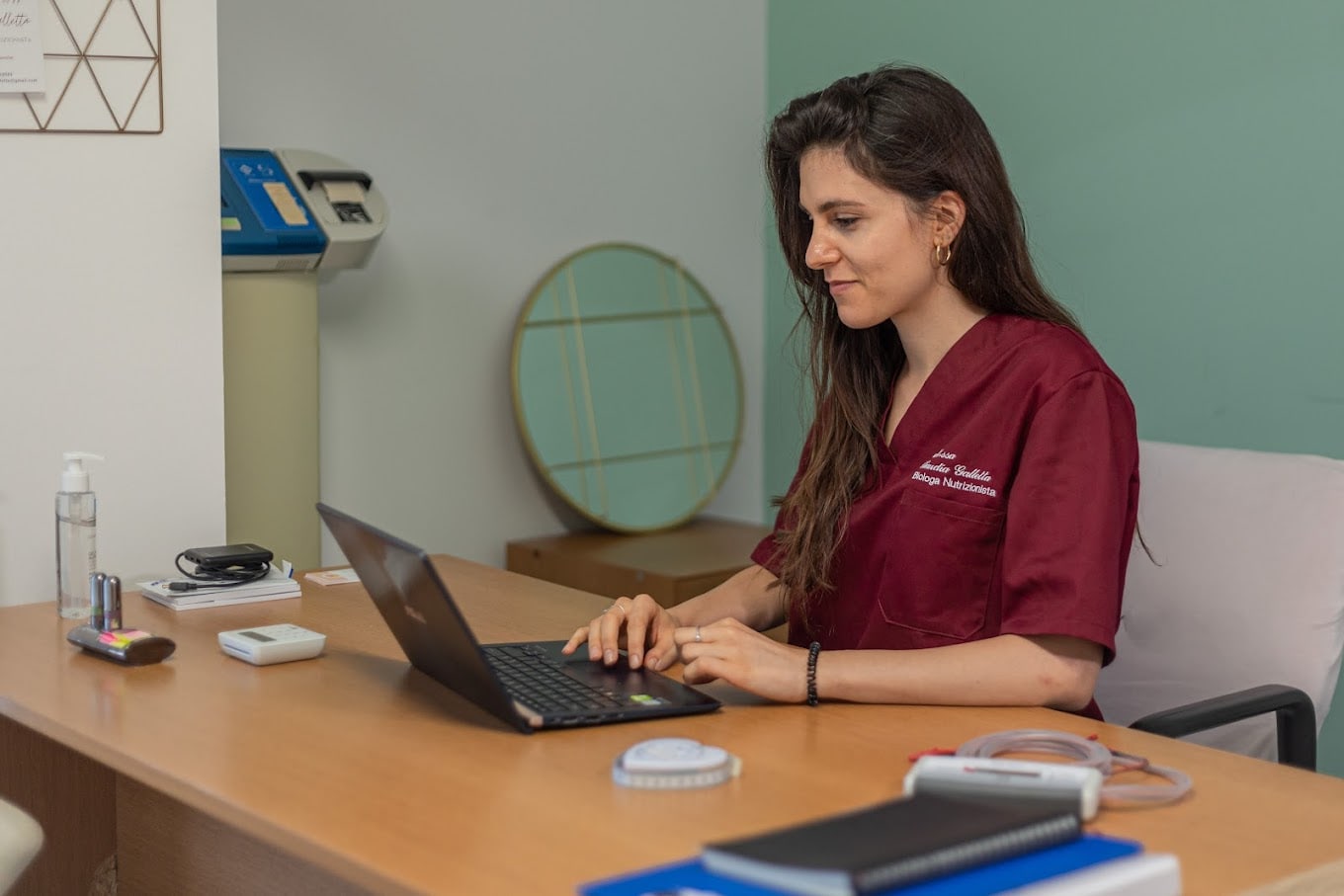 La biologa nutrizionista Claudia Galletta al lavoro nel suo studio, con la bilancia impedenziometrica sul tavolo